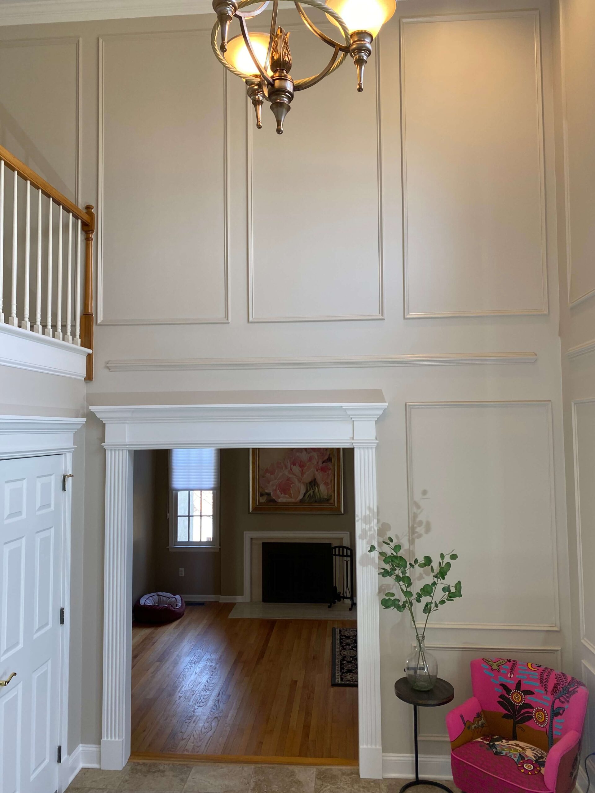 Two-story custom trim work, with paneled walls, architectural doorway trim, chandelier, and fine interior painting.